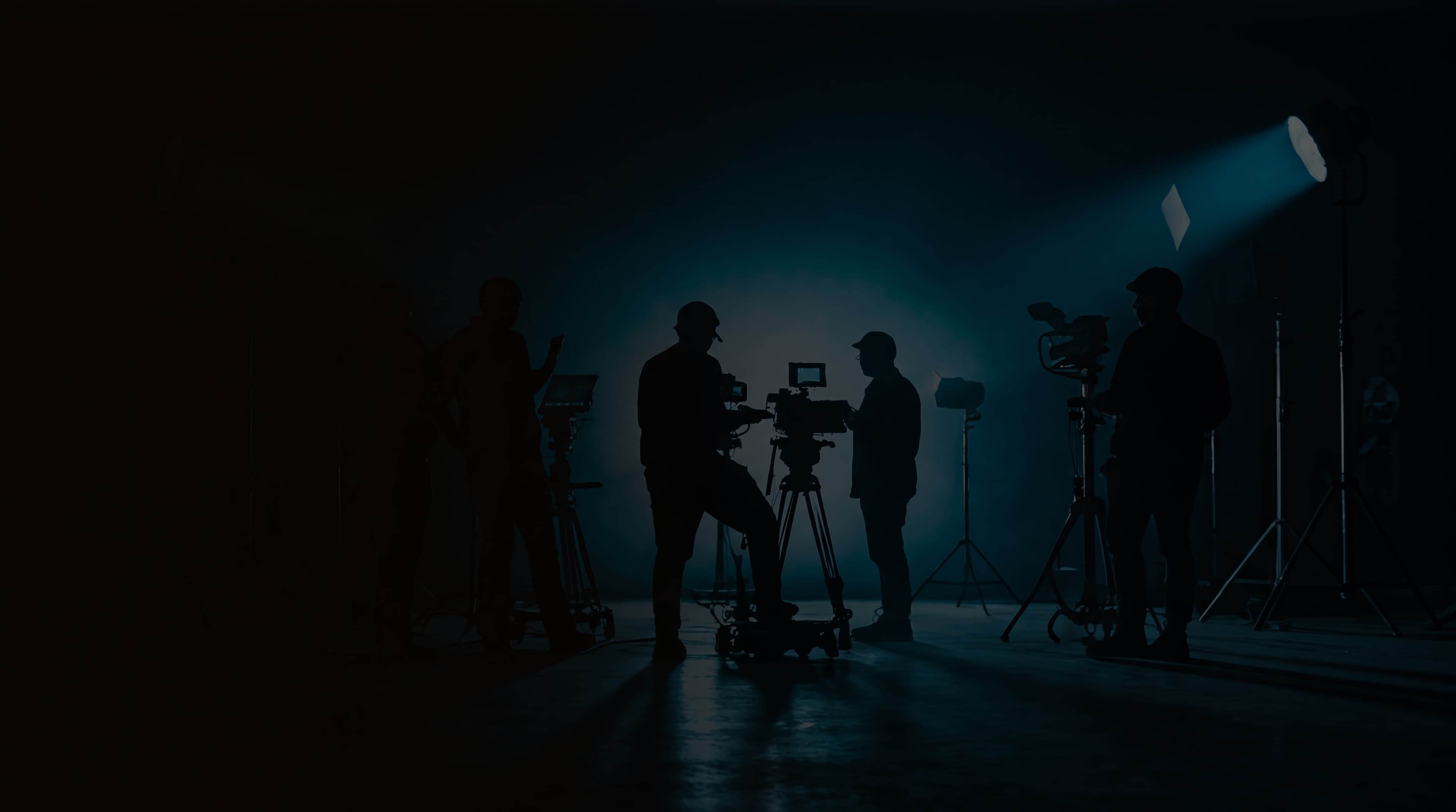 Filmset mit Kamerateam bei der Arbeit — cinematische Silhouetten im blauen Gegenlicht